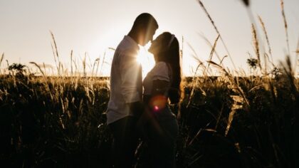 Romantic couple standing close together in grassy valley